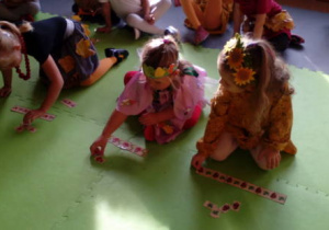 Trzy dziewczynki układają jesienne rytmy czyli szaliki P. Jesieni.
